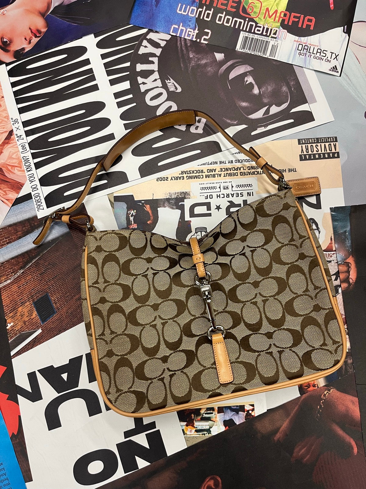 Coach kabelka přes rameno menší hnědá s monogramem značky, světle béžovými koženými prvky a malou stříbrnou přezkou